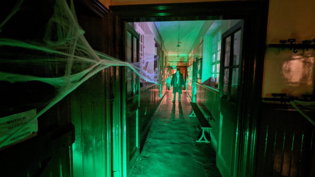 Spooky School at Beamish Museum during Halloween, cobwebs and terrifying man at end of corridor