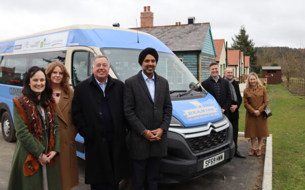 Four people stand to the left of a minibus, three people to the right of the mini bus which has the Beamish Museum logo on the bonnet. L-R Michelle Kindleysides, Beamish’s Head of Health and Wellbeing, Beth Marsden, Beamish’s Health & Support Worker, Jamie Martin of Ward Hadaway, Gurpreet Jagpal of Durham Group, Mark Stephenson of Stephenson-Mohl, Andrew Scott of Stanley Travel and Liz Peart, Partnerships Officer at Beamish.